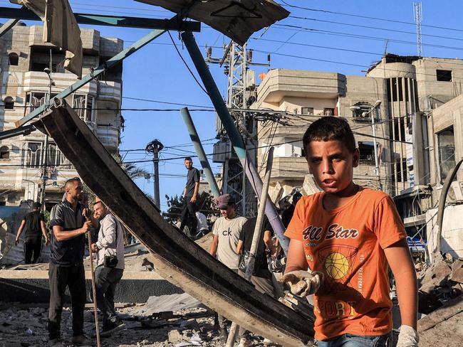 A boy inspects the rubble of a collapsed building in the aftermath of Israeli bombardment at the Jaouni school run by the UN Relief and Works Agency for Palestine Refugees (UNRWA) in Nuseirat in the central Gaza Strip on July 6, 2024 amid the ongoing conflict in the Palestinian territory between Israel and Hamas. (Photo by Eyad BABA / AFP)