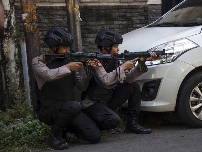 Mobile brigade police take position as they patrol outside the Surabaya police headquarters following a suicide attack in Surabaya. Picture: AFP