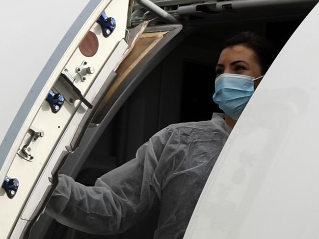 An air hostess closes the aircraft door after boarding is completed. Picture: AP