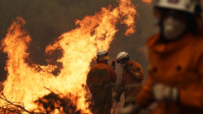 Fire in Judbury from a bushfire that started at Riveaux Road, South West. Tasmania Fire Service personnel put out a spot fire threatening a home on Donnelleys Road, Geeveston. Picture: LUKE BOWDEN