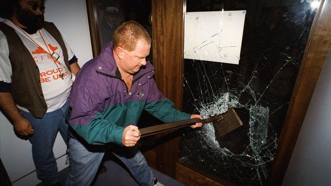 Protesters smash through the glass door of the souvenir shop to gain access to Parliament House during the Canberra riot in 1996. 