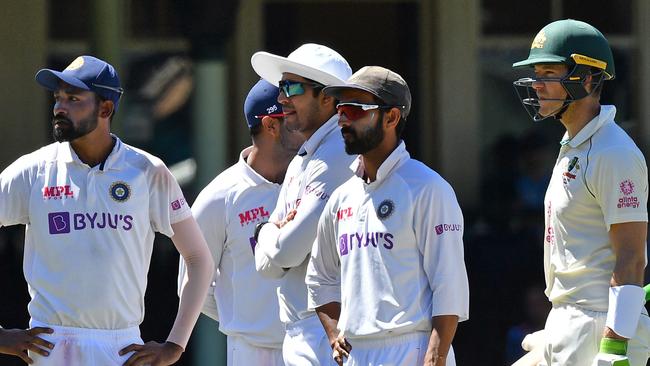 Indian players with Australian captain Tim Paine after play was stopped following complaints of abuse. Picture: AFP