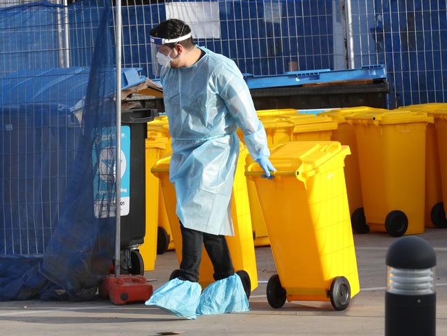 A worker is seen removing waste from Epping Gardens Aged Care home. Picture: David Crosling