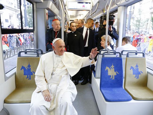 Pope Francis waves to a cheering crowd of faithful as he drives by in a public transportation tram he used to reach the venue of the World Youth Days in Krakow, Poland in 2016. Picture: AP
