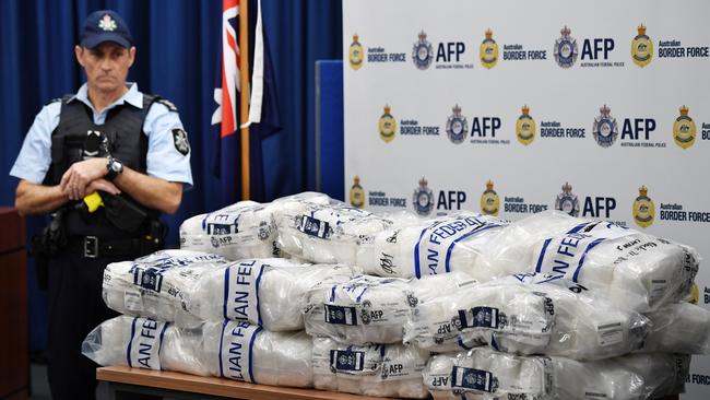 An Australian Federal Police officer beside bags of crystal methamphetamine seized last year. Picture: AAP 