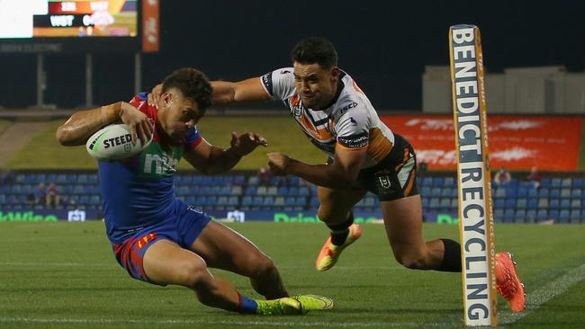 Starford To'a of the Newcastle Knights scores a try despite the efforts of David Nofoaluma of the Wests Tigers during the round 13 NRL match between the Newcastle Knights and the Wests Tigers. To'a is being investigated over a potential COVID breach.