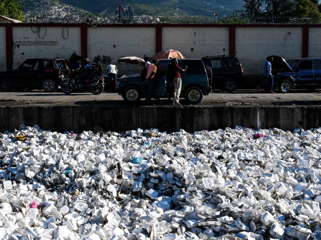 TOPSHOT - Plastic waste is seen floating on a sewage canal in the Haitian capital Port-au-Prince, on April 23, 2019. (Photo by CHANDAN KHANNA / AFP)