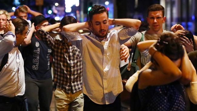 People rush through the street with their hands up after a terror attack in London. Picture: Reuters