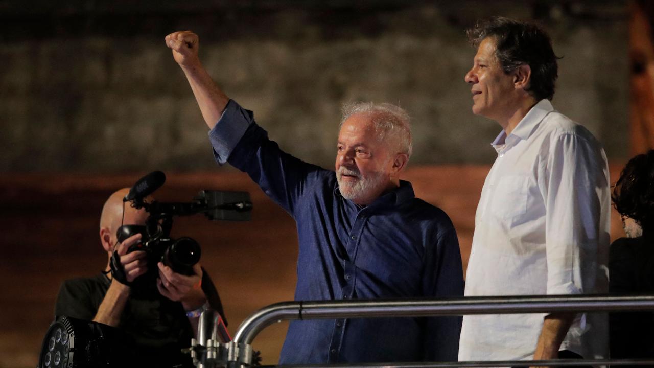 Brazilian president-elect for the leftist Workers Party (PT) Luiz Inacio Lula da Silva (L) and Sao Paulo Governor candidate Fernando Haddad greet supporters at the Paulista avenue after winning the presidential run-off election, in Sao Paulo, Brazil, on October 30, 2022. – Brazil's veteran leftist Luiz Inacio Lula da Silva was elected president Sunday by a hair's breadth, beating his far-right rival in a down-to-the-wire poll that split the country in two, election officials said. (Photo by CAIO GUATELLI / AFP)