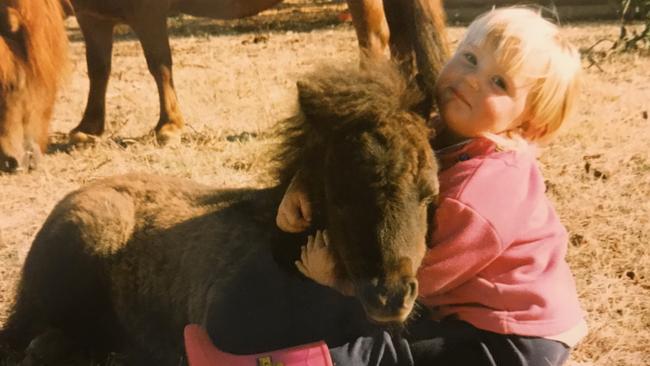 A young Jamie Kah gives her pony a hug. Picture: Supplied