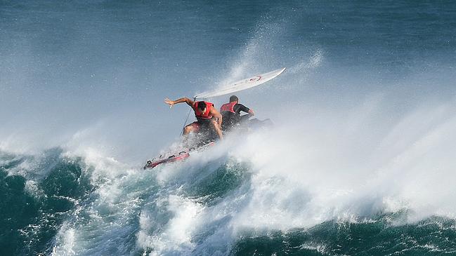 A jetski rider negotiates a wave as he transports a surfer in large surf at Kirra on the Gold Coas. (AAP Image/Dave Hunt)