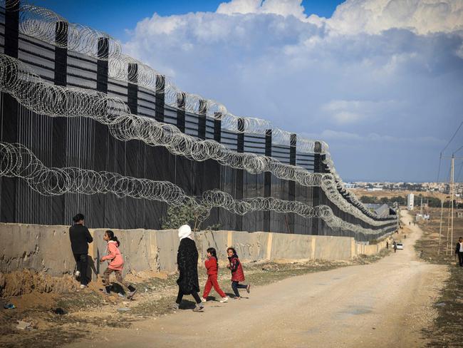 Displaced Palestinians walk along the Philadelphi Corridor – a narrow buffer zone along the Gaza Strip's border with Egypt, west of Rafah in the southern Gaza Strip. Picture: AFP