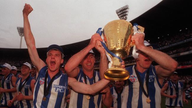 Dean Laidley (left) and Craig Sholl (centre) with the premiership cup. 1996 Grand Final. North Melbourne (Kangaroos) v Sydney Swans. MCG.