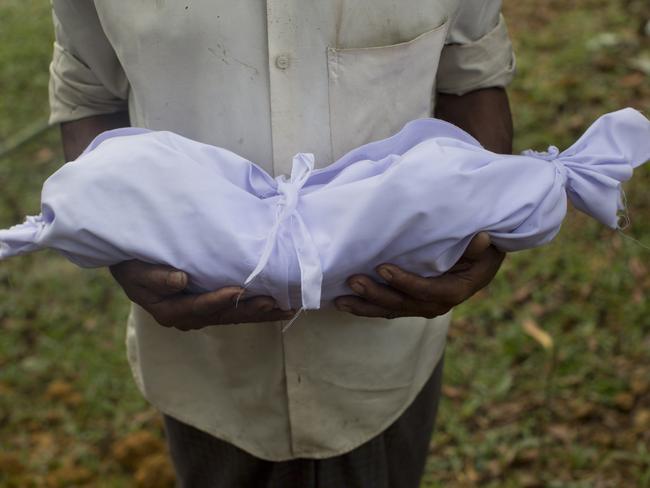 A Rohingya man holds the body of a two-day-old baby before his burial at Kutupalong’s refugee camp cemetery in Bangladesh last Friday. Picture: Bernat Armangue/AP