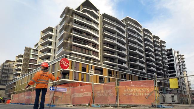 This photo taken on June 17, 2016 shows a worker holding a stop sign in front of an apartment block under construction in Sydney. Sydney is imposing new taxes on foreigners buying homes amid growing concerns that a flood of mostly Chinese investors is crowding out locals and killing the "Great Australian Dream" of owning property. / AFP PHOTO / WILLIAM WEST / TO GO WITH Australia-China-property-tax,FOCUS by Glenda KWEK