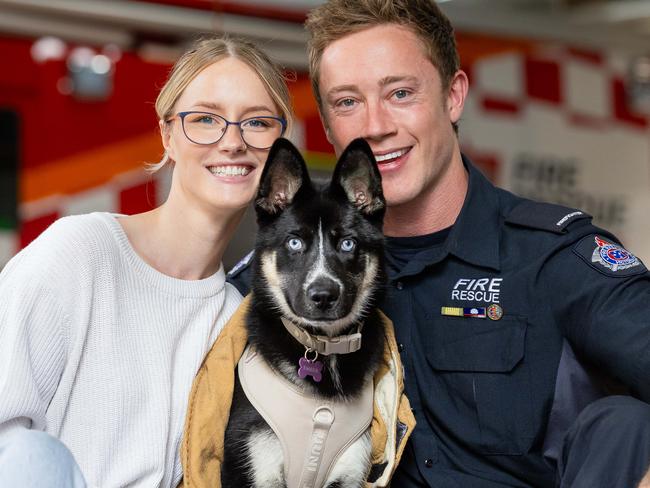 Firefighter Alex Eldridge with German Shepherd cross Husky puppy, Ember and partner Jordan Trabert. Alex rescued Ember after a factory fire in Sunshine. Picture: Jason Edwards