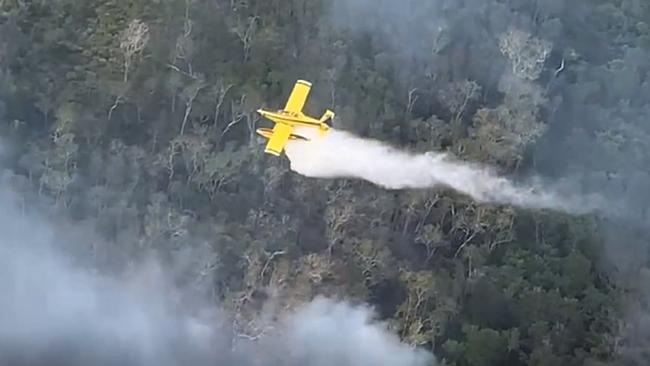 A water-bombing aircraft tries to douse a fire burning on Fraser Island.