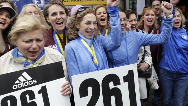 Kathrine Switzer, middle, the first official woman entrant in the Boston Marathon 50 years ago, cheers at a news conference, Tuesday, April 18, 2017, in Boston, where her bib No. 261 was retired in her honour by the Boston Athletic Association.
