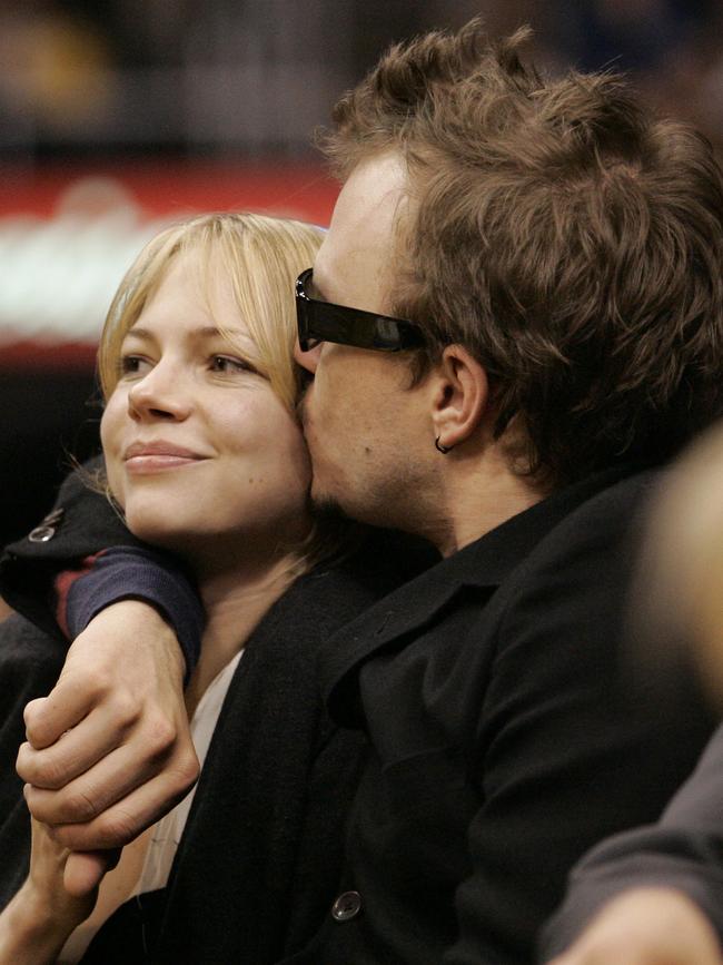 Ledger plants a kiss on the cheek of girlfriend Williams at a basketball game in Los Angeles in 2006. Picture: Francis Specker / AP Photo