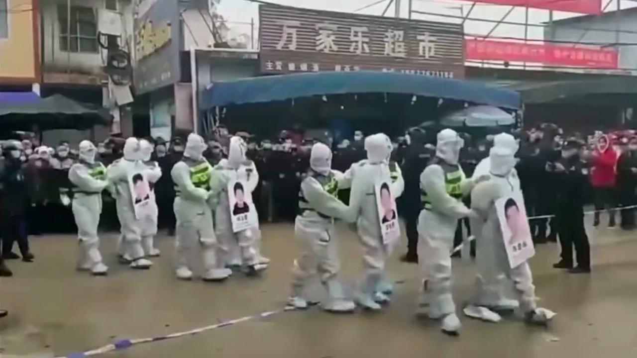 In a bid to increase compliance, a group of men who allegedly flouted lockdown restrictions have been marched through the streets of China’s Jingxi in a ‘shaming parade’ by armed police. Picture: Twitter