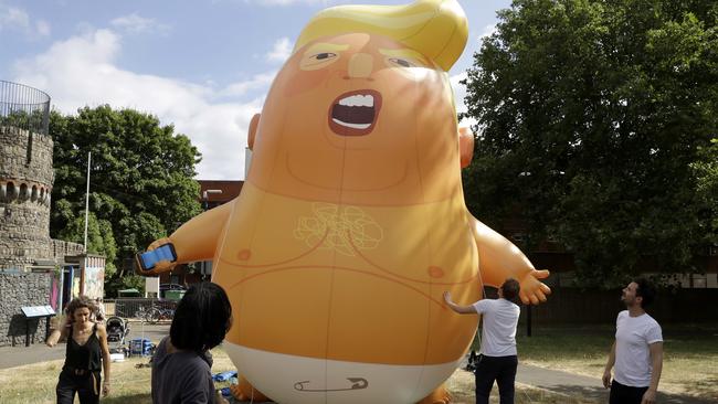 A six-metre high cartoon baby blimp of Donald Trump stands inflated during a practice session in north London. Picture: AP.