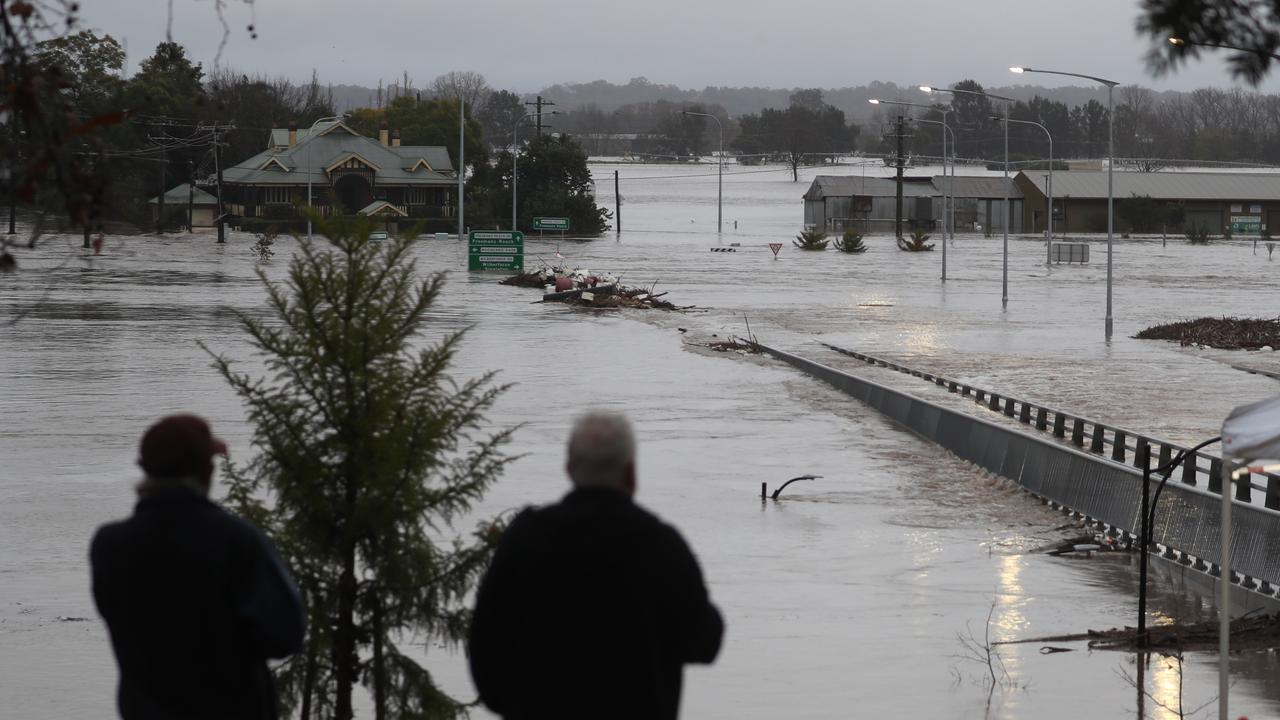 Residents watch as Windsor Bridge is consumed by water once again. Picture: John Grainger