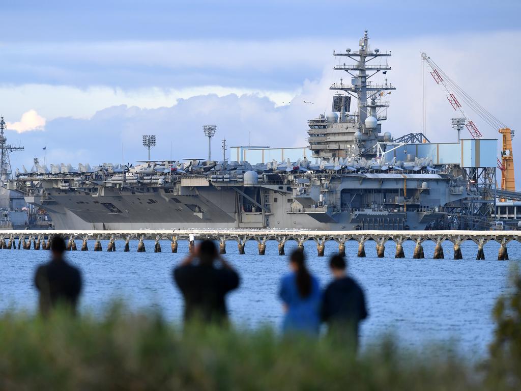 Locals look at the aircraft carrier USS Ronald Reagan, docked at the Port of Brisbane.