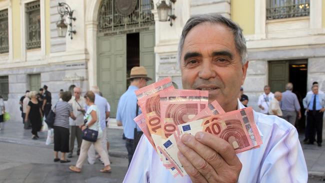 Pensioner Giorgos Petropoulos shows ten euros notes who receive from National Bank of Greece in Athens, Wednesday, July 1, 2015. Pensioners are the forgotten victims of the Greek crisis. Their monthly payments have been cut in recent years, and since many lack bank cards they were totally cut off from their funds until Wednesday’s special bank sessions allowed them partial access. (AP Photo/Spyros Tsakiris)