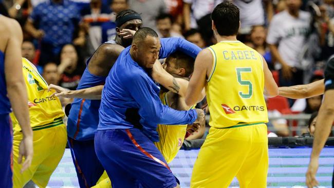 Nathan Sobey is set apon by two Philippines players. Picture: EPA/MARK R. CRISTINO