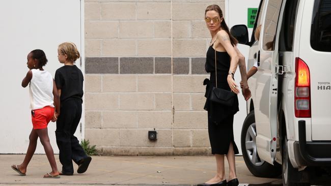 Angelina Jolie assists her chidren out of the van.