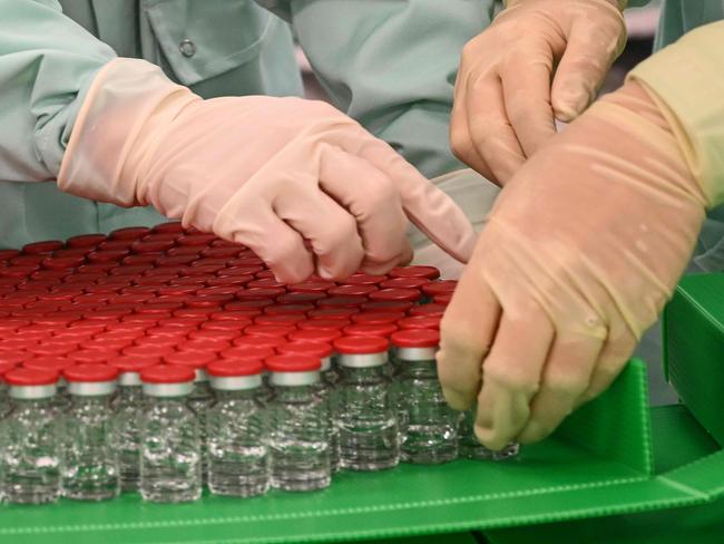 (FILES) In this file photo taken on September 11, 2020 Laboratory technicians handle capped vials as part of filling and packaging tests for the large-scale production and supply of the University of Oxfordâs COVID-19 vaccine candidate, AZD1222, conducted on a high-performance aseptic vial filling line at the Italian biologicsâ manufacturing facility of multinational corporation Catalent in Anagni, southeast of Rome. - Financial markets were less giddy November 10, 2020, but eked out some gains nonetheless and oil prices rose on strong hopes for a coronavirus vaccine. News from the US pharmaceutical group Pfizer and Germany's BioNTech about excellent phase-three results for their candidate vaccine "seems to have been a game changer, even if experts warn that production and distribution may take time," remarked Fawad Razaqzada, an analyst at ThinkMarkets. (Photo by Vincenzo PINTO / AFP)