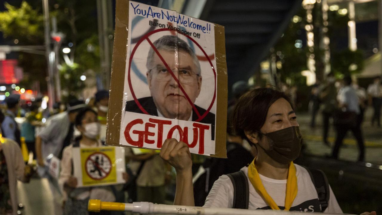 A protester holds a placard of International Olympic Committ. Picture: Getty Images