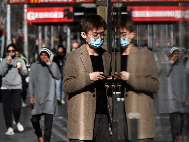 People walk through a quiet shopping area in the central business district of Sydney on July 2, 2021, after more than 10 million Australians have been ordered into lockdown as coronavirus cases spread across the country. (Photo by Saeed KHAN / AFP)