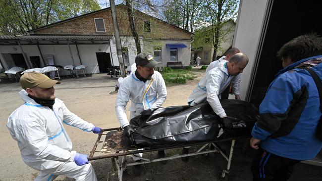 Mortuary workers unload a bag containing a body of a victim in Bucha. Picture: Genya Savilov/AFP