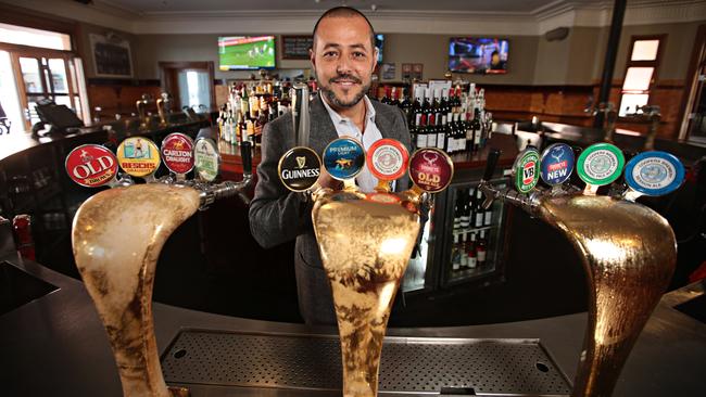 Sam Arnaout behind the taps of one of his pubs. Picture: AAP/Adam Yip