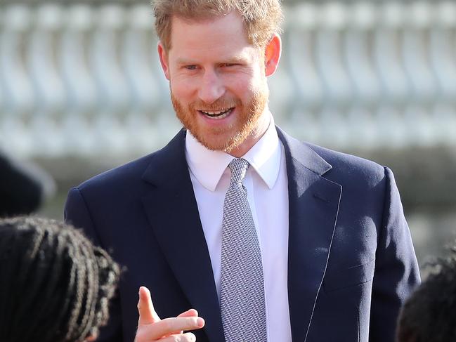 Prince Harry chats with young rugby league players on the lawn of Buckingham Palace on his way inside. Picture: Getty