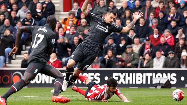 Southampton's Shane Long goes down under the challenge from Liverpool's Dejan Lovren.