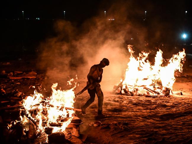 A worker helps cremate the bodies of COVID-19 victims on the banks of the Ganges River. Picture: Getty Images