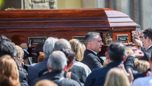 The coffin is carried from the church by family members. Picture: Jake Nowakowski