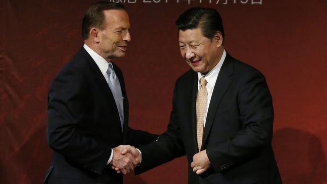 Xi Jinping and Australia's then-Prime Minister Tony Abbott shake hands on stage after they both addressed the Australia China state and provincial leaders forum in Sydney. Picture: Jason Reed