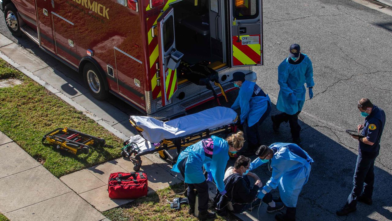 LA paramedics administer oxygen to a potential COVID-19 patient on the sidewalk before taking him to a hospital. Picture: Apu Gomes/AFP