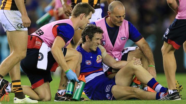 Robert Murphy grabs his left knee after collapsing to the ground. Picture: Wayne Ludbey