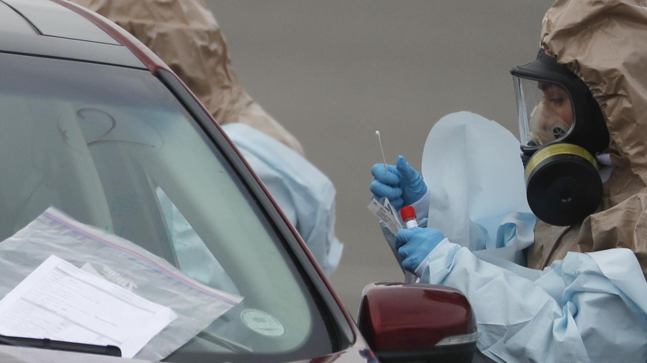 National Guard medical personnel perform coronavirus test on a motorist at a drive-through testing site outside the Denver Coliseum in Colorado. Picture: David Zalubowski