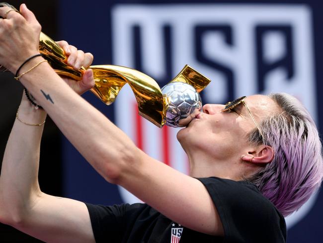 TOPSHOT - USA women's soccer player Megan Rapinoe kisses the trophy in front of the City Hall after the ticker tape parade for the women's World Cup champions on July 10, 2019 in New York. - Tens of thousands of fans are poised to pack the streets of New York on Wednesday to salute the World Cup-winning US women's team in a ticker-tape parade. Four years after roaring fans lined the route of Lower Manhattan's fabled 