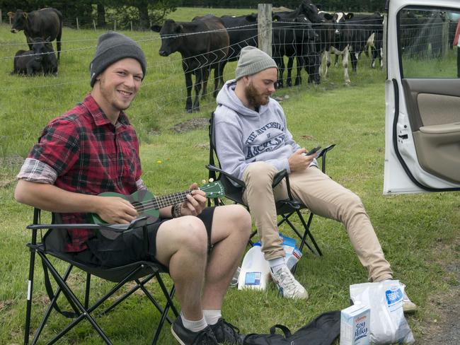 German tourists Robin Tohermes, left, and Niels Gallo sit out in a slowly swelling traffic queue by road blocks, in Christchurch, New Zealand. Picture: AP
