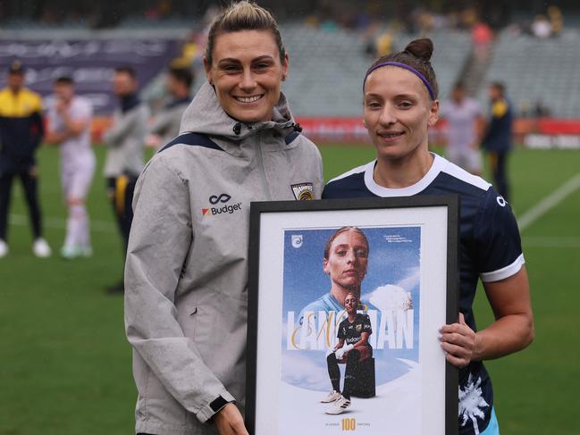 Mariners coach Emily Husband presents Langman with a framed photo in honour of her 100th match. Picture: Scott Gardiner/Getty Images