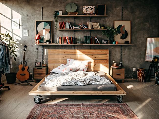 Interior of modern bedroom in the sunny morning, clothes hanging on bar