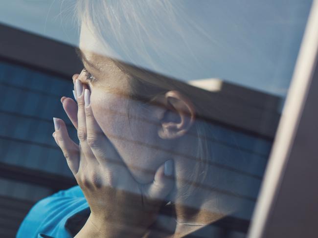 Businesswoman sitting in the car and covering her mouth in shock. The view is through glass. istock woman scared