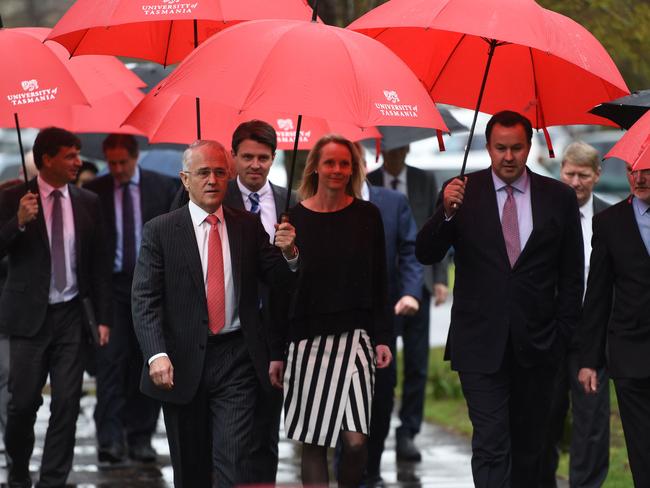 Australian Prime Minister Malcolm Turnbull (centre left) leads a group along through the rain during a tour of the University of Tasmania's School of Architecture and Design yesterday. Picture: Scott Gelston