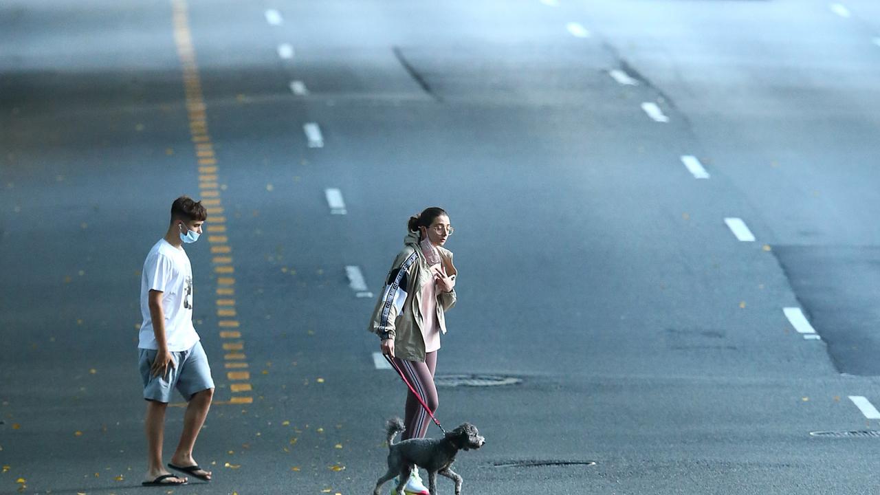 Pedestrians in a quiet Brisbane CBD after lockdown kicked off at 4pm on Saturday. Picture: Jono Searle/Getty Images)